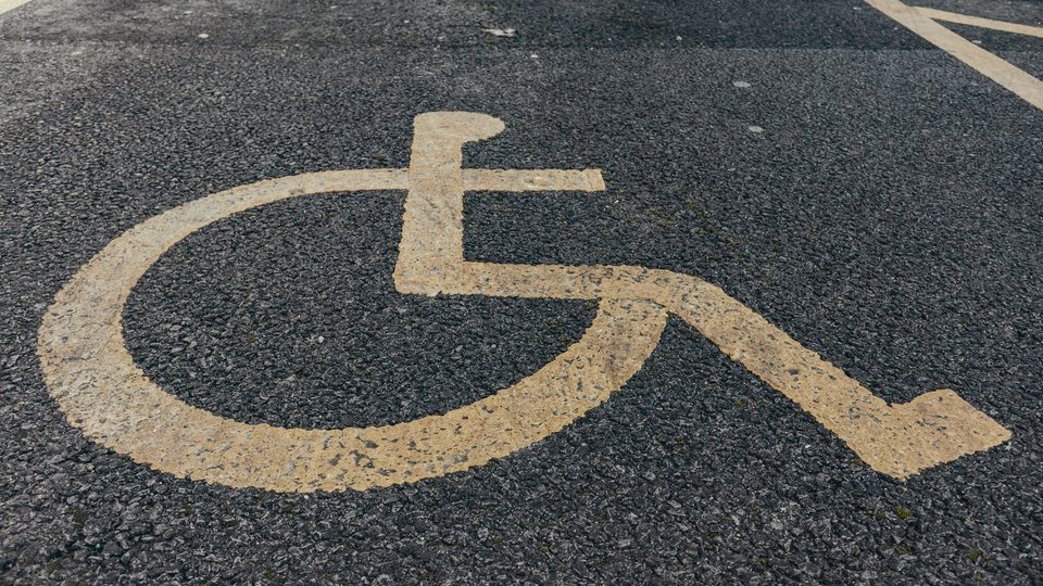 Painted accessibility symbol on an asphalt parking stall