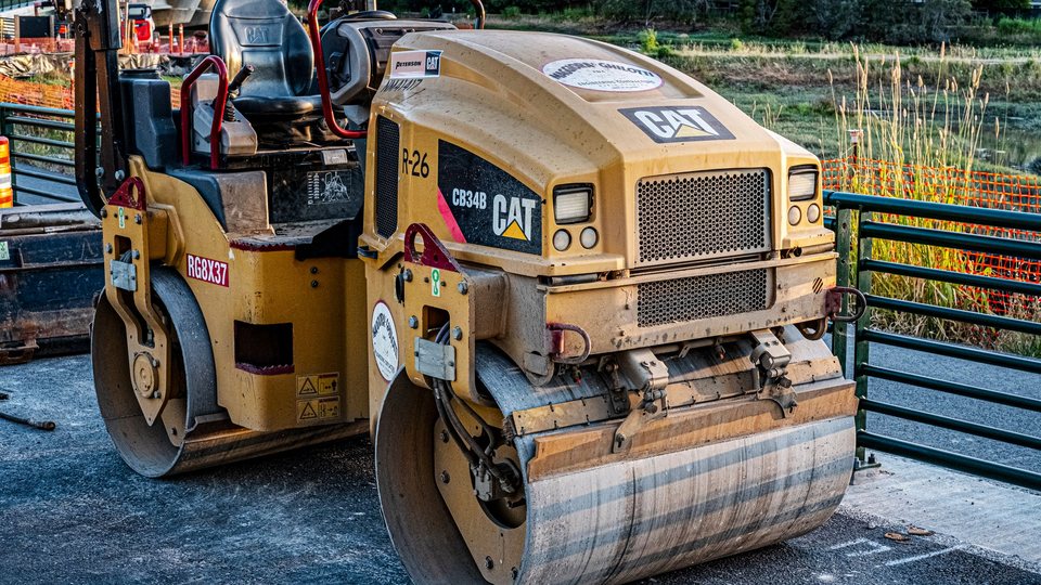 Tandem asphalt roller parked at a paving job site